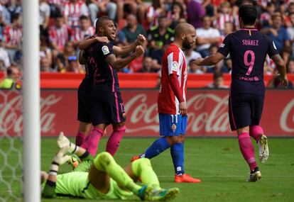El delantero brasileño del FC Barcelona Rafinha Alcántará (i) celebra con sus compañeros, el defensa Sergi Roberto, y el delantero uruguayo Luis Suárez (d), autor del primer gol, el segundo tanto del equipo frente al Sporting de Gijón.