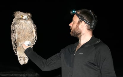 Jonathan C. Slaght con un búho pescador en 2007 en Rusia.