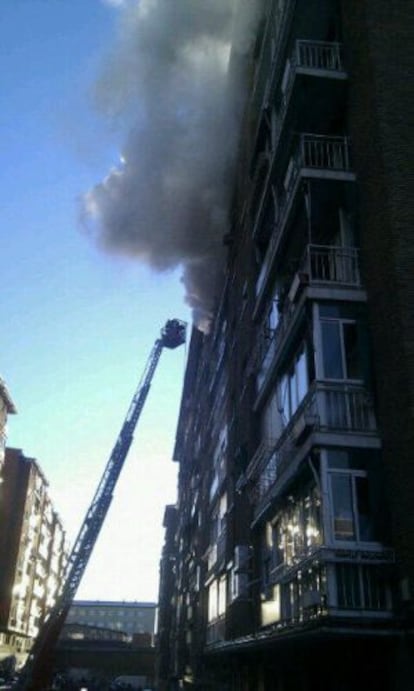Los bomberos tratan de acceder a la vivienda siniestrada.