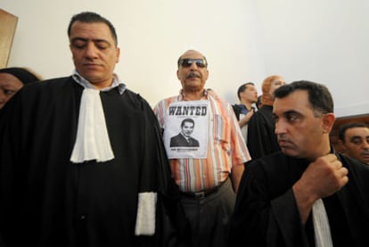 "Buscado por su dictadura", dice el cartel que lleva este hombre al inicio del juicio contra Ben Ali en Túnez.
