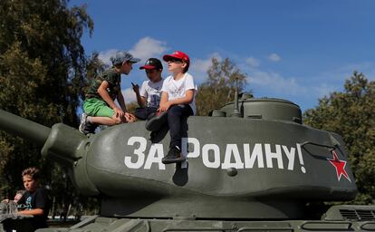 Niños rusos juegan sobre un tanque en el que reza "¡Por la Patria!" en un parque de Moscú.