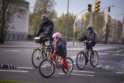 Un adult i dos nens en bicicleta per Barcelona.