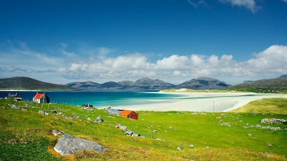 En las blanquísimas playas de Harris, una de las principales <a href="https://www.visitouterhebrides.co.uk/" target="_blank">islas de las Hébridas Exteriores</a>, frente a la costa oeste de Escocia, el mayor tesoro son las propias islas: poco pobladas, llenas de rabiosas tempestades y días frescos incluso en verano. Por eso son tan fascinantes. Da gusto ponerse un jersey de 'tweed' de Harris tejido a mano. En la imagen, el arenal de Luskentyre desde la localidad de Seilebost, en la isla de Harris. A la izquierda de la foto despunta la isla de Taransey.