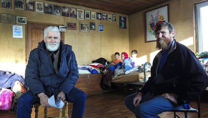 Fedor Kronikovski (a la izquierda) conversa con Ulián Murashov (derecha). Al fondo, los dos hijos de la familia, Agripina y Filaret, junto a otro niño.