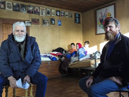 Fedor Kronikovski (à esquerda) conversa com Ulian Murashov (à direita). Ao fundo, os dois filhos da família, Agripina e Filaret, junto a outra criança.