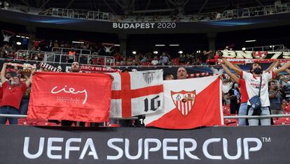 Seguidores del Sevilla sostienen banderas en la grada antes del partido.