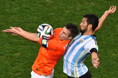 Robin van Persie (i) y Ezequiel Garay (d) se disputan un bal&oacute;n a&eacute;reo.