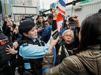 Un miembro del personal de seguridad detiene a un simpatizante que ondea la bandera de la Unión Jack a las puertas del Tribunal de Magistrados de West Kowloon durante el juicio al magnate de los medios de comunicación Jimmy Lai, en Hong Kong, este lunes.