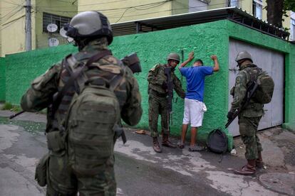 Soldados cachean a un vecino de una favela, en R&iacute;o de Janeiro.