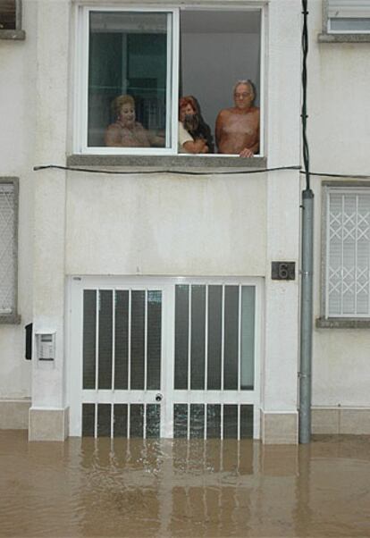 Vecinos de Salou observan los bajos de su casa inundados.