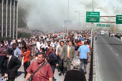 Miles de personas abandonan Manhattan a pie por el puente de Brooklyn tras los atentados del 11-S.