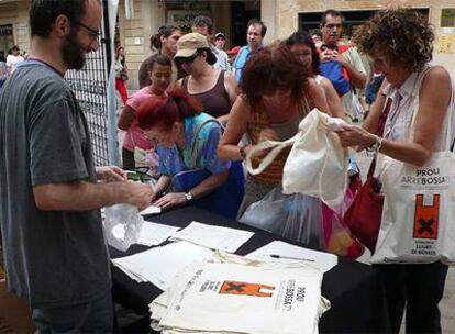 Unas señoras cambiando bolsas de plástico por otras de tela en el día sin bolsas de plástico en Cataluña.