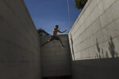 Guille Ibáñez realiza un salto mientras practica 'parkour' en una calle de Madrid (España).