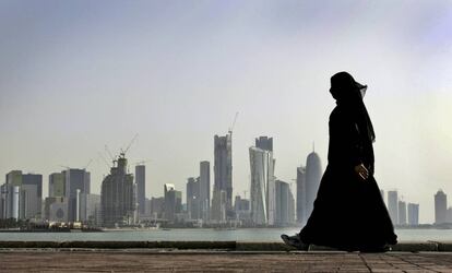 Una mujer catarí camina frente al centro de Doha.