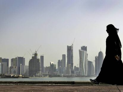 Una mujer catarí camina frente al centro de Doha.