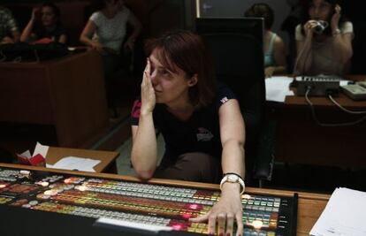 Una de las empleadas de la televisión se limpia las lágrimas en una de las salas de control, ayer en la sede en Atenas.