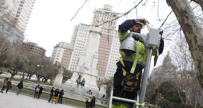 Un operario instala una cámara de vigilancia en la plaza de España.