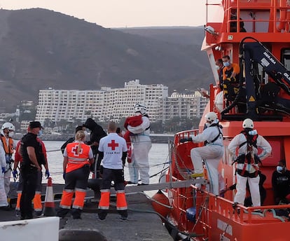 Miembros de la Cruz Roja ayudan a bajar del barco a migrantes en el puerto de Arguineguín (Gran Canaria, España) a 17 de marzo de 2021. 79 inmigrantes de origen subsahariano que viajaban a bordo de dos pateras fueron trasladados esa tarde noche por Salvamento Marítimo hasta el muelle de Arguineguín, en el Sur de Gran Canaria,  después de rescatarlos en alta mar. Entre ellos viajaban varios bebés, mujeres jóvenes y adultos. 