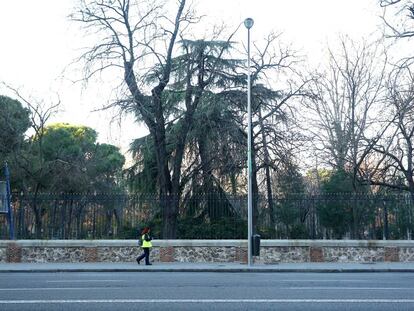 Una controladora del SER pasa por la zona azul de la calle Menéndez Pelayo, sin coches durante una alerta de contaminación de Madrid.