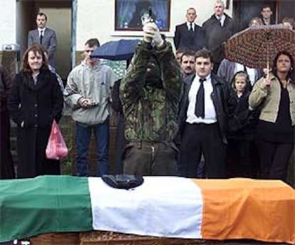 Un pistolero encapuchado del IRA real dispara al aire con una pistola durante el funeral de uno de sus colegas.