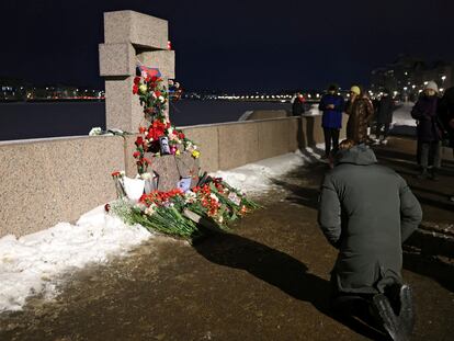 Una persona se arrodilla ante el monumento a las víctimas de la represión política en San Petersburgo tras conocerse la muerte del disidente Alexéi Navalni, este viernes.