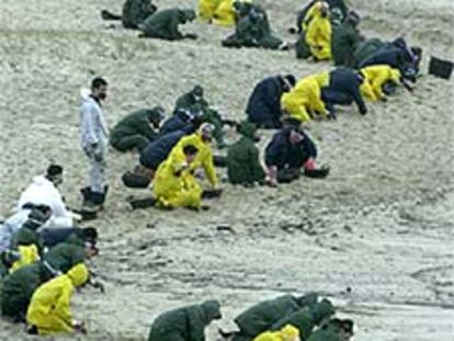 Grupos de militares limpian la playa de Ancoradoiro, en Muros (A Coruña).