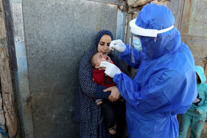 Un sanitario recoge una muestra de un niño para su análisis, en la franja de Gaza.