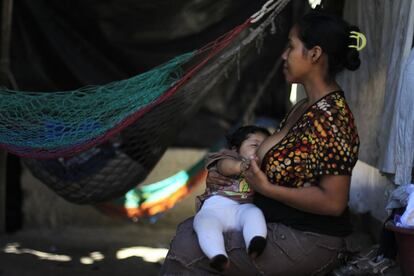 Una mujer amamanta a su hijo, en su casa, en un barrio pobre de San Salvador, 21 enero de 2014.