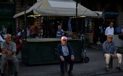 Varios hombres presencian la manifestaci&oacute;n del sindicato comunista griego, en Atenas, el pasado 23 de mayo