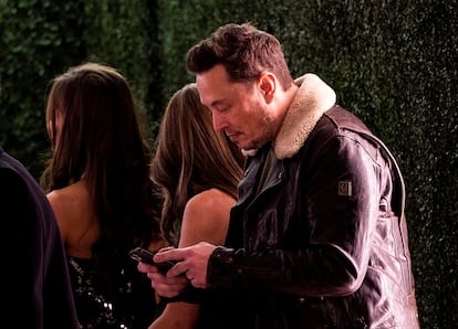 Elon Musk uses his phone before the premiere of ''Lola'' held at the Regency Bruin Theatre in Los Angeles, California, U.S.