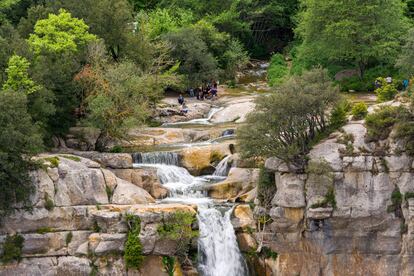 Varios excursionistas en el Salt de Sallent en Rupit, el mayor de Cataluña, en la comarca barcelonesa de Osona.