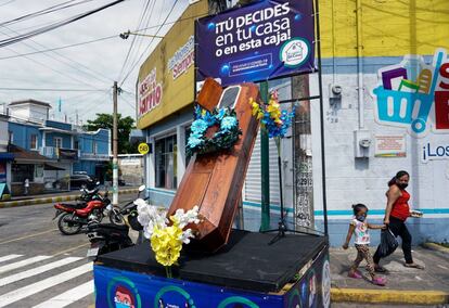 Una mujer y su hija caminan junto a un ataúd con un letrero que dice "Tú decides, en tu casa o en esta caja", en las calles del municipio de Escuintla, a 55 kilómetros al sur de Ciudad de Guatemala, durante una campaña de las autoridades locales para detener la pandemia del coronavirus. En los últimos cuatro meses, Guatemala registró 40.229 casos de covid-19, de los cuales 1.531 han muerto y 26.685 ya se han recuperado.