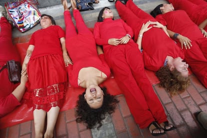 Activistas vestidas de rojo forman una alfombra humana para simbolizar aque los derechos de la mujer están siendo pisoteados, durante una protesta el 7 de marzo, víspera del Día Internacional de la Mujer