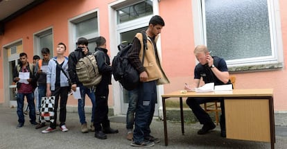 Un policía alemán registra a un grupo de demandantes de asilo en la estación de Freilassing, en el sur de Alemania, el pasado 15 de junio.