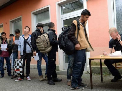 Un policía alemán registra a un grupo de demandantes de asilo en la estación de Freilassing, en el sur de Alemania, el pasado 15 de junio.