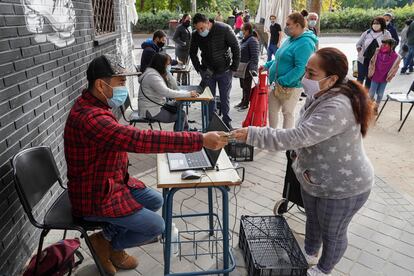 MADRID. 17-10-2020. Oficina improvisada en la calle para el reparto de comida a familias necesitadas en Aluche. Cada sábado se distribuyen varias toneladas de alimentos a personas golpeadas por la pandemia desde una red vecinal paralela a los canales oficiales de ayuda del Ayuntamiento. FOTO: LUIS DE VEGA