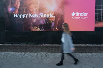 Una mujer pasea delante de un anuncio de Tinder en febrero en Berlin,
