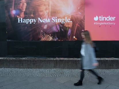 Una mujer pasea delante de un anuncio de Tinder en febrero en Berlin,