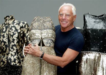 El diseñador Giorgio Armani posa con algunos de los modelos que integran la exposición <i>Una retrospectiva</i>.