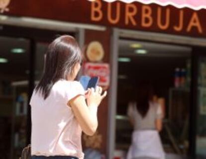 Una usuaria utiliza su smartphone en una calle de Madrid.