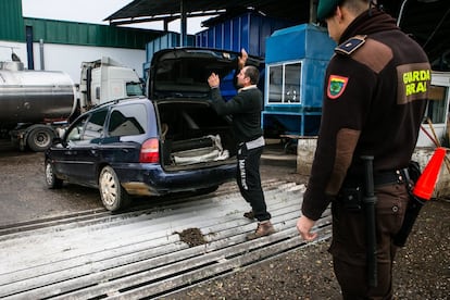Uno de los supuestos ladrones cogidos por la guardia rural, abre el maletero de su coche en la cooperativa San Isidro, adonde los han conducido para obligarles a descargar la mercancía.