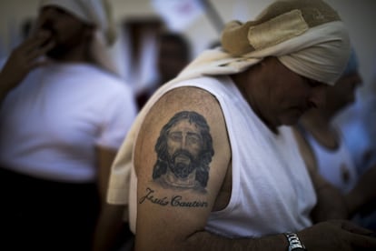 Un costalero con la imagen tatuada de Jesús el Cautivo se prepara para una procesión en Sevilla, el 14 de abril de 2019.