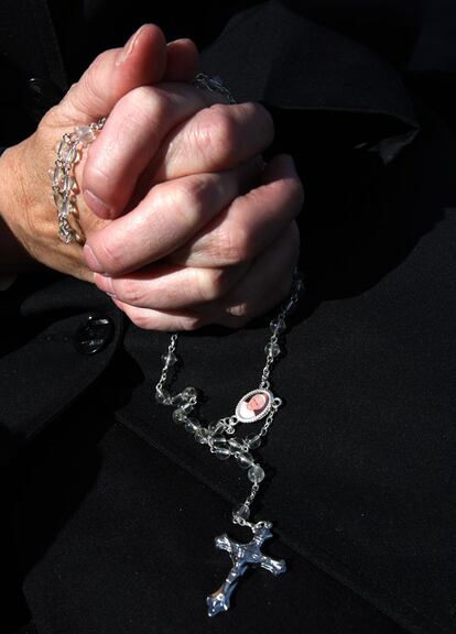 Un monje sostiene un rosario, a la espera de la misa que se va a celebrar en Bellahouston Park, Glasgow.