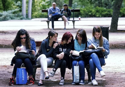 Un grupo de j&oacute;venes lee en un banco en la Feria del Libro de Madrid.