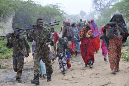 Un grupo de refugiados escoltado por soldados del Gobierno de transición somalí camina por un barrio de Mogadiscio.