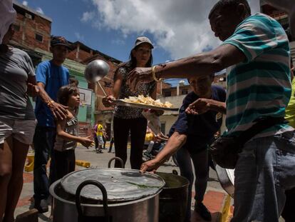 Un grupo de personas prepara una sopa en un barrio de favelas de Caracas en 2016. 