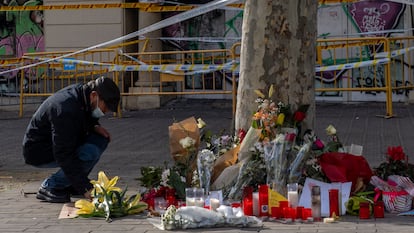 Una persona deja flores en el homenaje a la familia muerta en el incendio del local en el que vivían.