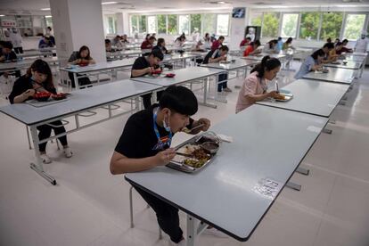 Trabajadores de Renesas Electronics almuerzan respetando la distancia como medida preventiva contra la propagación del coronavirus, en Pekín (China).