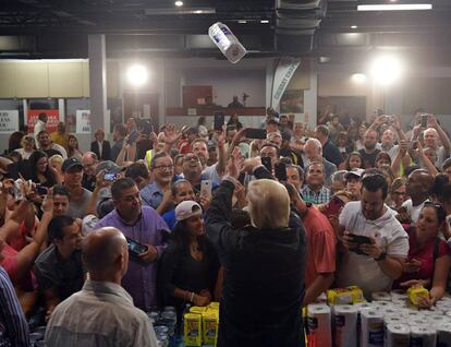 Trump arroja rollos de papel a damnificados por el huracán María.