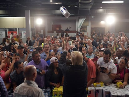 Trump arroja rollos de papel a damnificados por el huracán María.